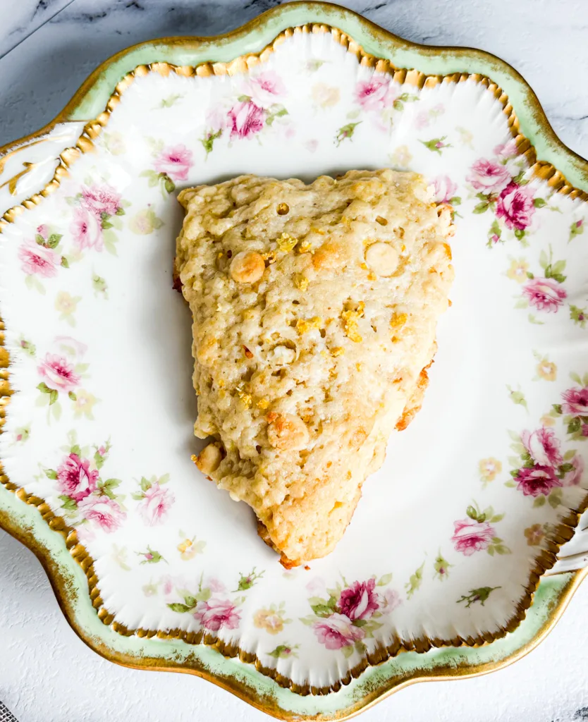 A sourdough scone with white chocolate and lemon on a platter.