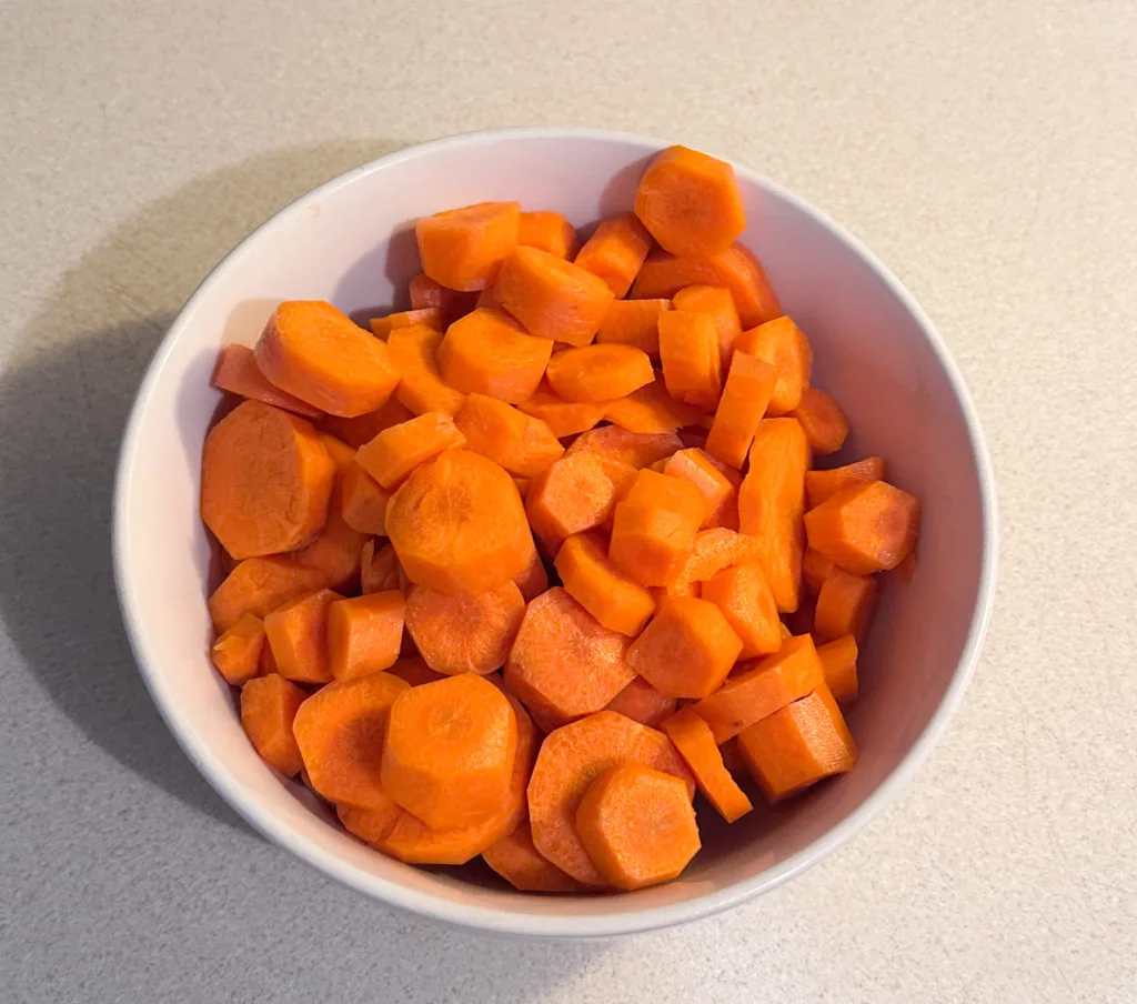A bowl of carrots, sliced into coin shapes.