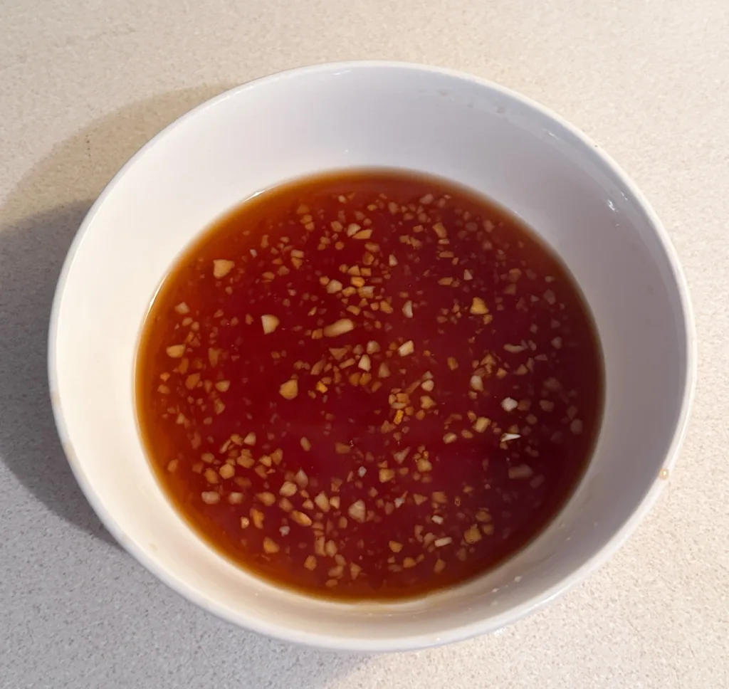 A bowl of soy sauce, honey, garlic, and apple cider vinegar.