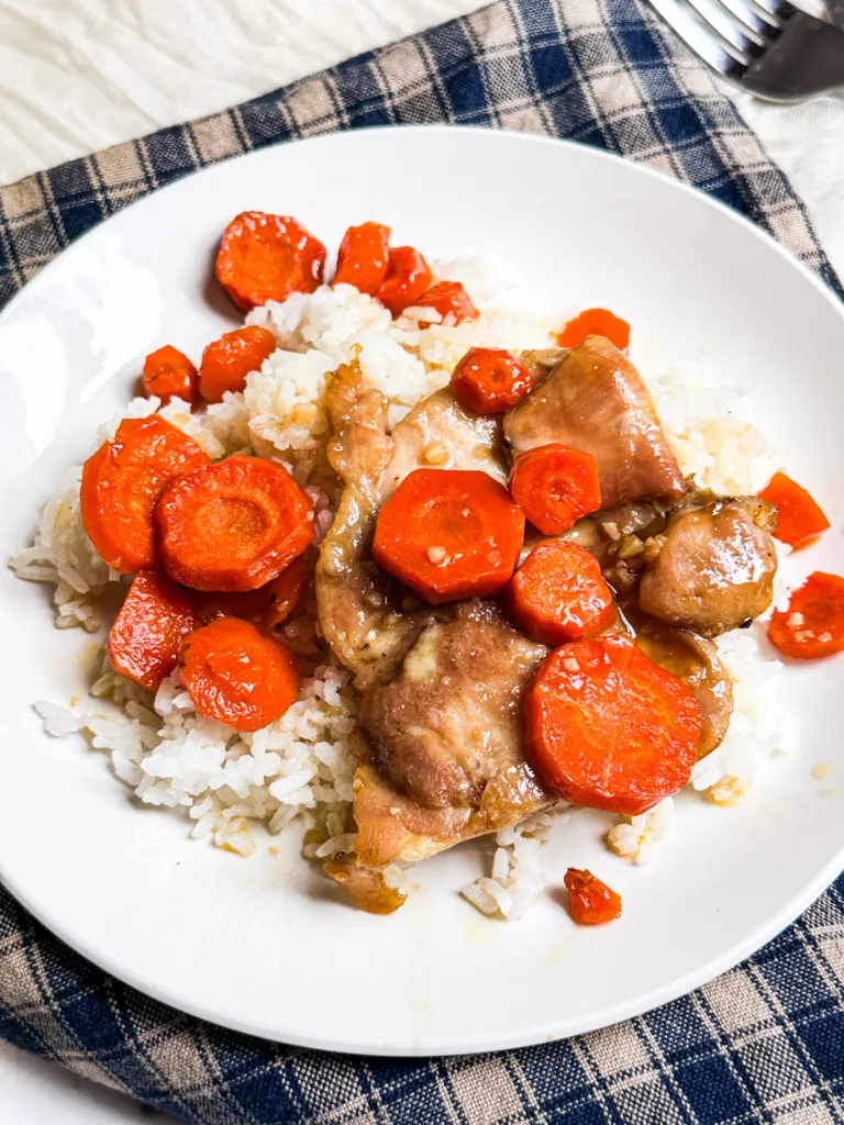 Honey garlic chicken thighs on a plate with rice.