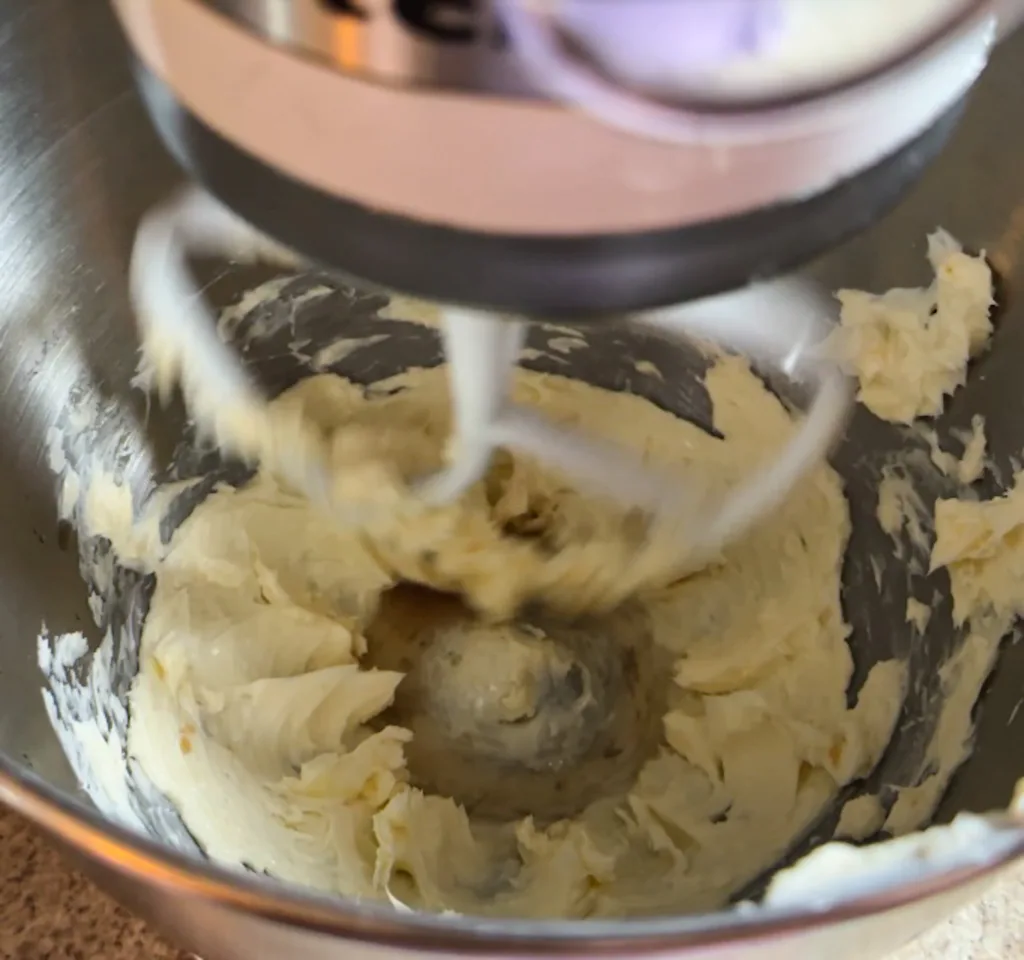 A stand mixer mixing butter.