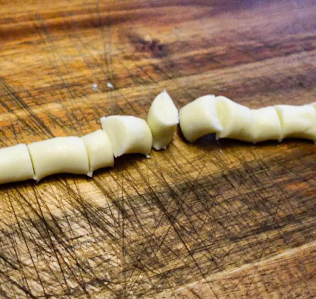 Butter mints cut into "pillow shaped" pieces on a cutting board.