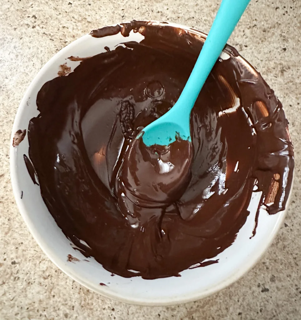 Melted chocolate in a white, glass bowl.