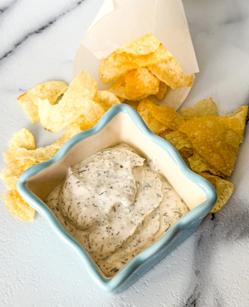 Sour cream dip next to potato chips.