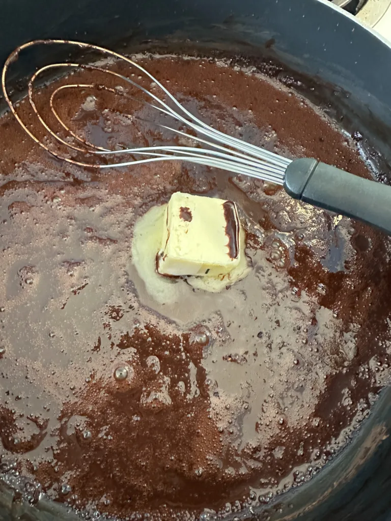 Butter added to a pan with cocoa powder, maple syrup, and milk.