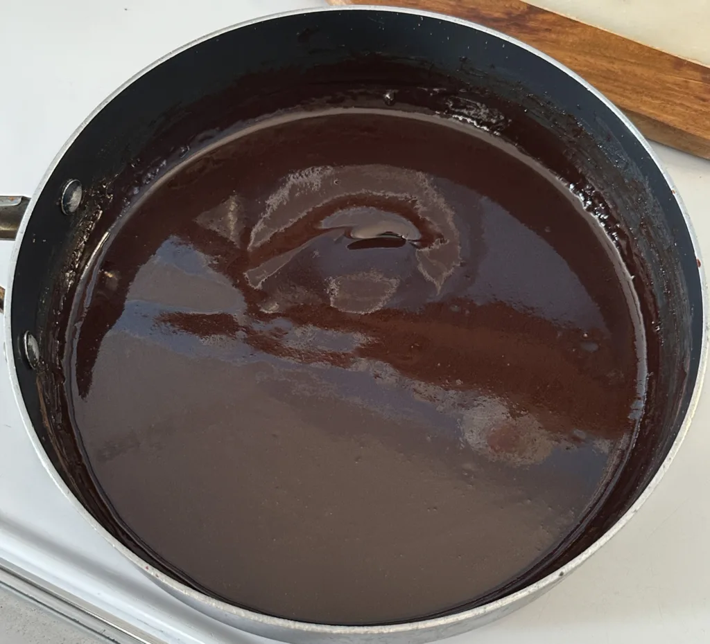A pan with cocoa powder, maple syrup, milk, and butter all melted together.