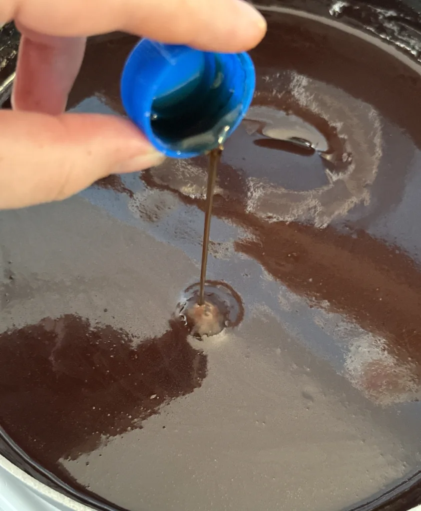 Vanilla extract being poured into my chocolate sauce recipe.
