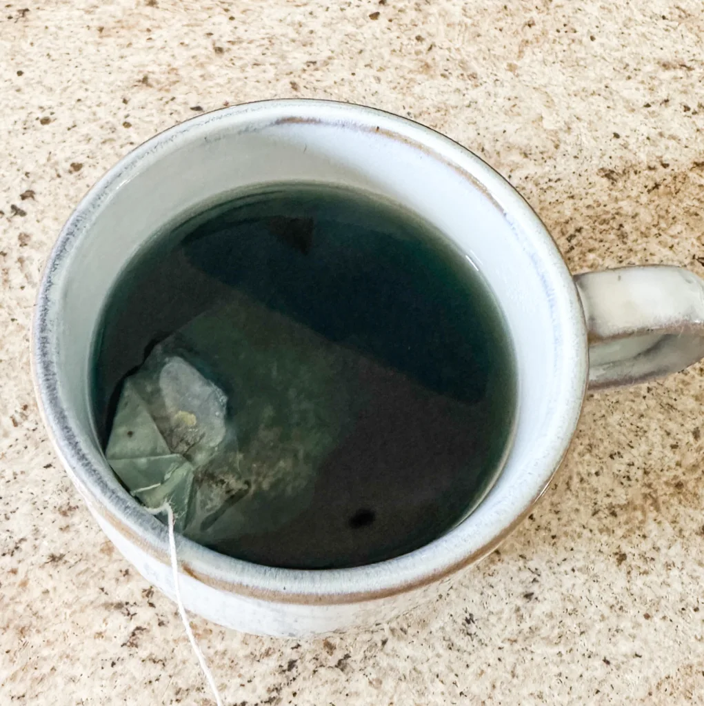 A tea bag brewing in a mug.