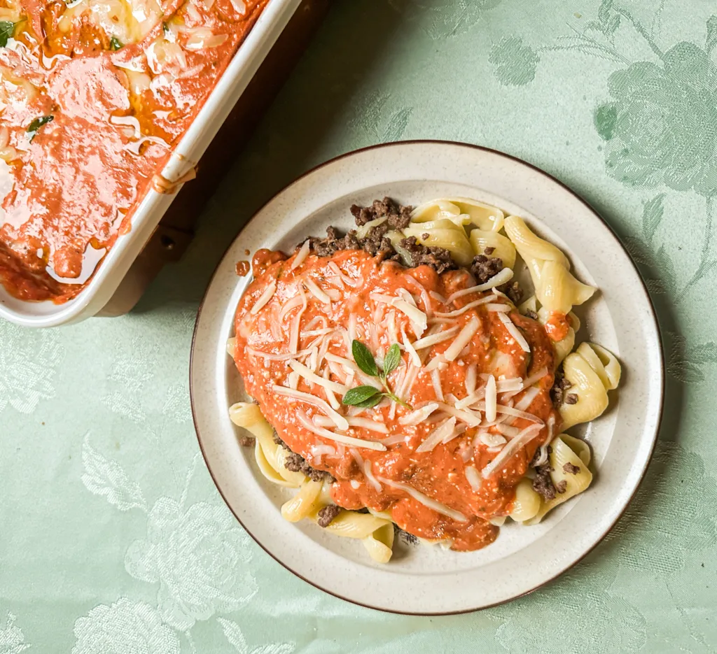 Cream cheese pasta on a plate with cheese, ground beef, and noodles.