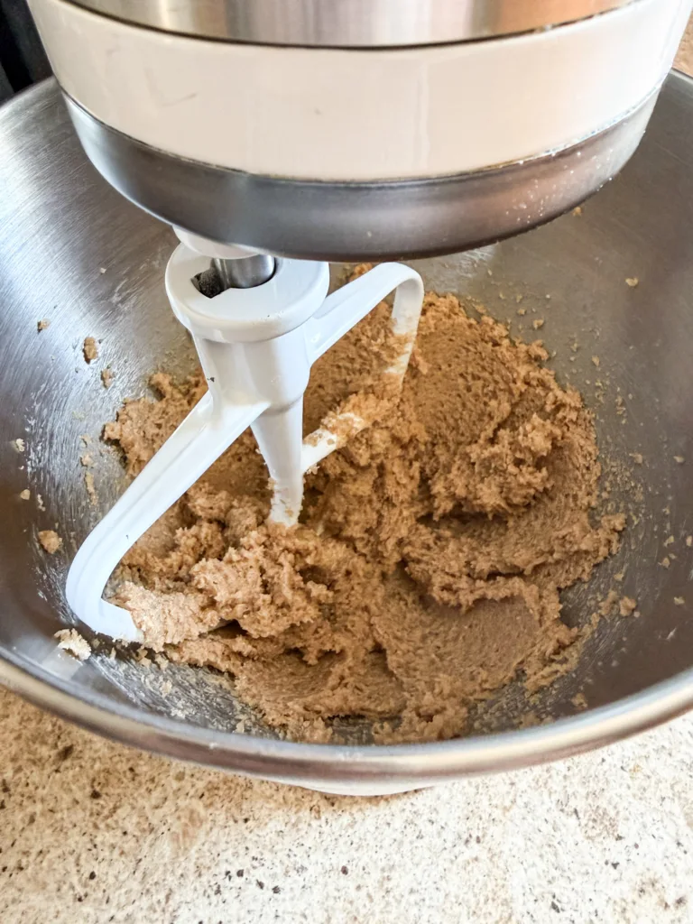 A stand mixer, mixing together peanut butter, butter, and sugar,