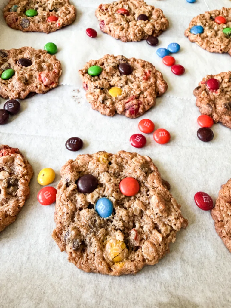 Einkorn monster cookies on a baking sheet with M&M's around them.