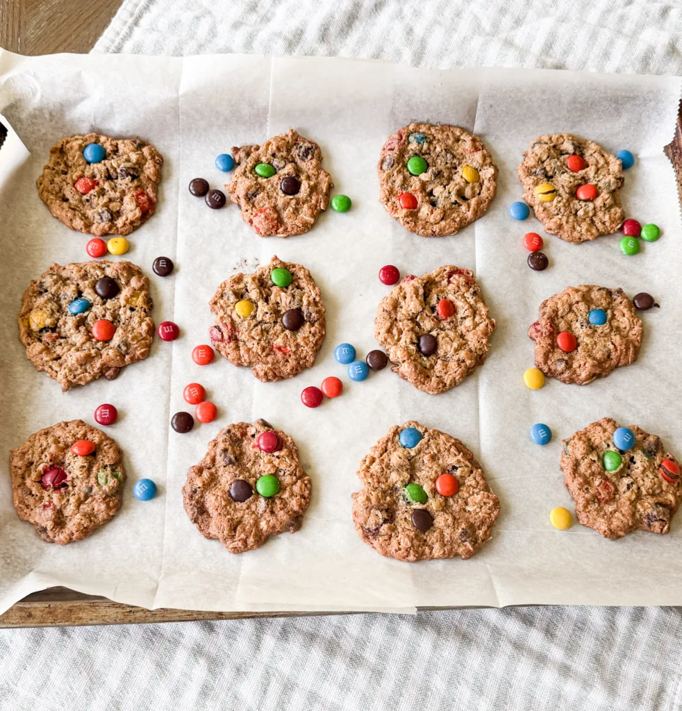 Einkorn monster cookies on a baking sheet with M&M's around them.