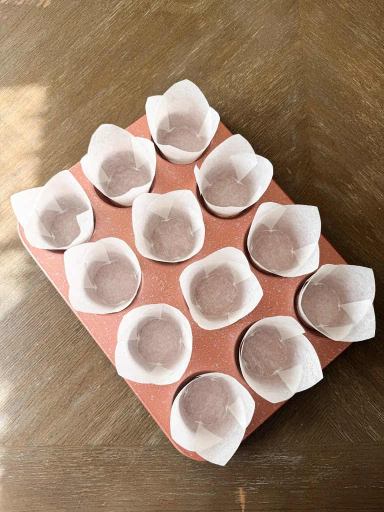 A muffin tin with muffin liners in it.