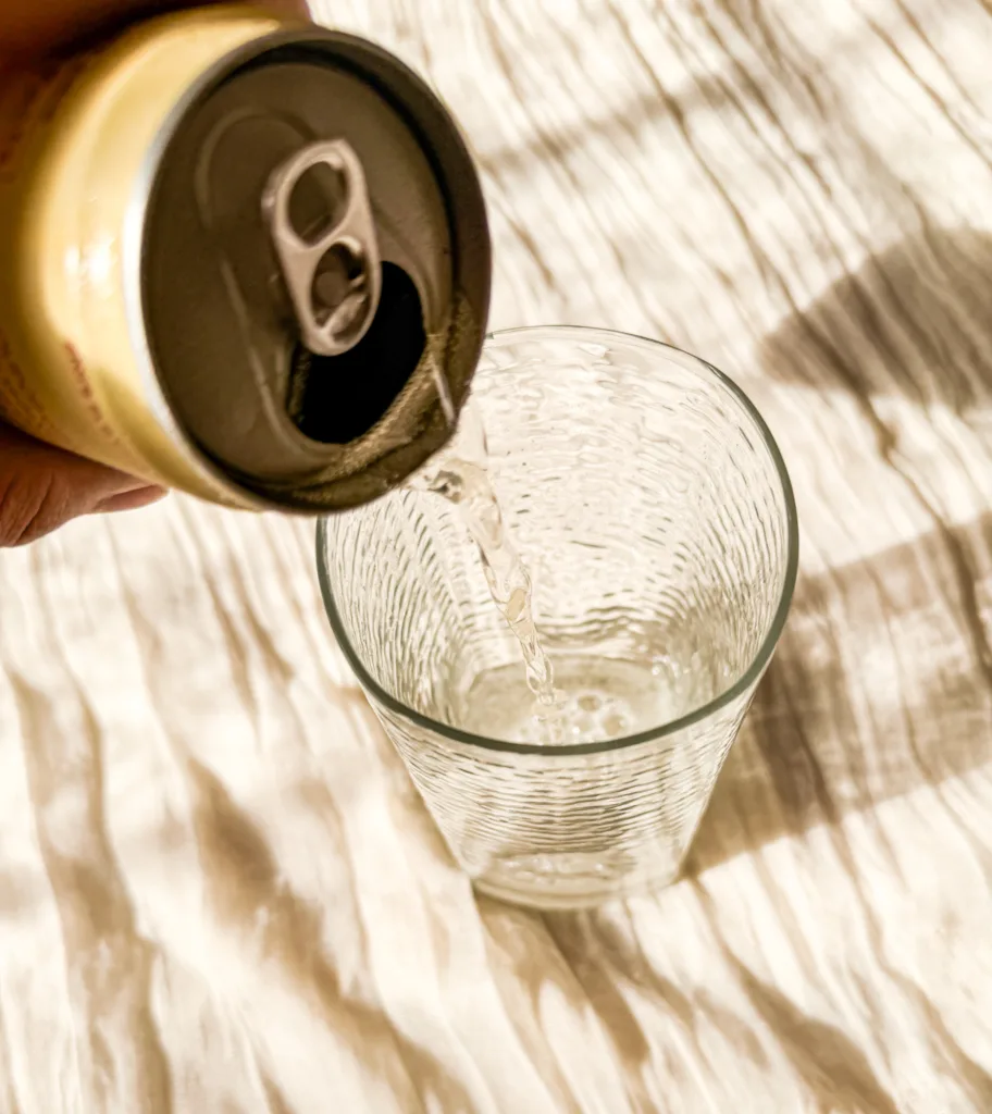 Pop being poured into a glass cup.