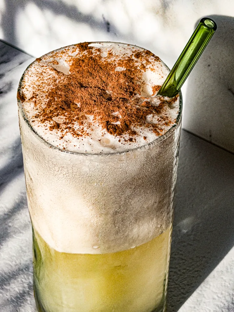 Apple dirty soda float in a tall glass with a straw.
